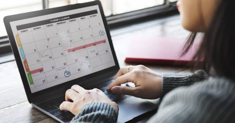 Person on laptop looking at social media calendar